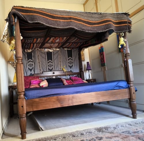 Wooden four-poster canopy bed with black and orange fabric drape in the Marsupilami room at Le Lama Zébré guesthouse,