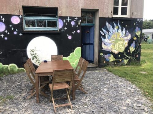 Holzessttisch im Gartenhofe mit farbenprächtigem kosmischem Blumenmotiv im Le Lama Zébré, Penmarch