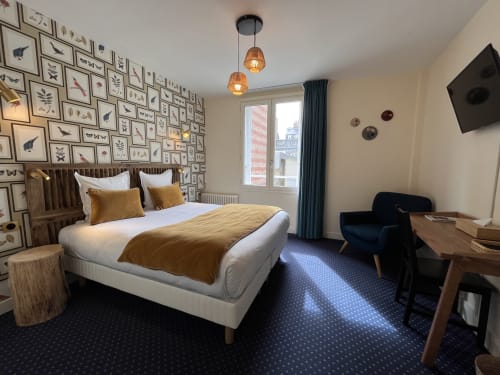 Hotel Le Trouville comfort double room with bird-themed wallpaper, wooden bed, and city view from Trouville sur Mer.