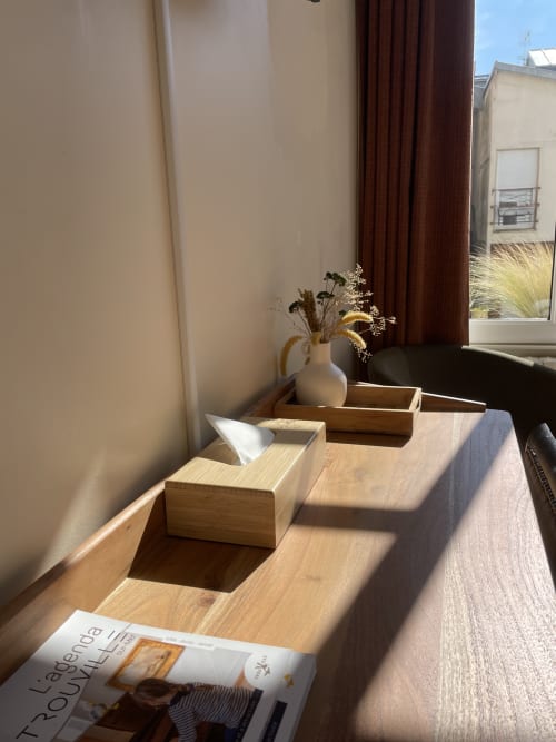 Sunny windowsill at Hotel Le Trouville with wooden boxes, white vase with dried flowers, and magazine