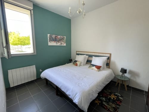 Chambre moderne aux Prairies du Val d'Amboise, Noizay avec mur d'accent bleu-vert, lit queen et décoration contemporaine