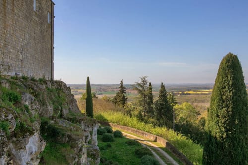 Bâtisse en pierre avec cyprès dominant les collines de Lectoure, vue de gîte Alombre