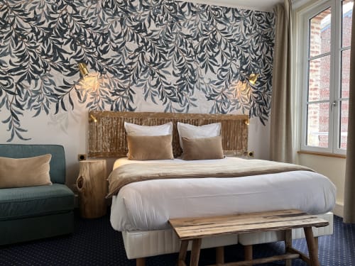 Luxury hotel bedroom at Le Trouville with patterned wallpaper, wooden bed frame, and city view windows in Trouville sur Mer