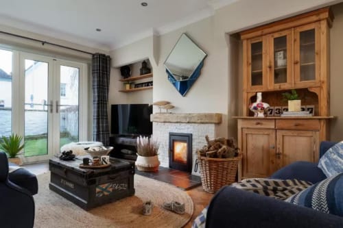 Cozy living room at 2 Doves Holiday Property in Exeter with fireplace, wooden furnishings, and waterfront views