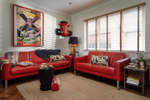 Modern living room at 2 Doves Holiday Property, Exeter with red leather sofas, vintage poster, wooden blinds