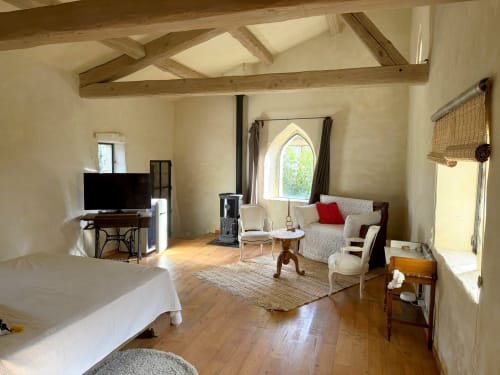 Spacious studio at La Grange Neuve B&B in Potelières with exposed beams, bed, seating area and arched window