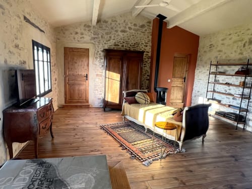 Spacious bedroom at La Grange Neuve B&B in Potélières with stone walls, wooden bed, and rustic decor
