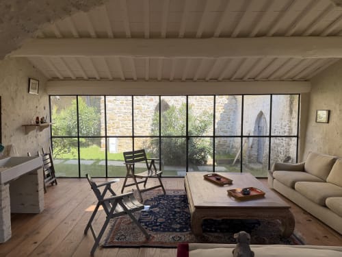 Modern living room at La Grange Neuve B&B in Potélières with large windows, wooden furniture, and garden views