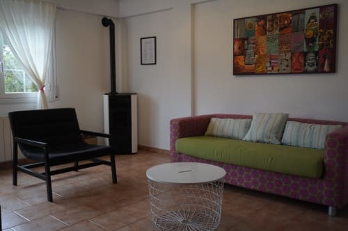 Salón moderno en Bizkar Bare, Vizcaya con sofá púrpura, silla negra, chimenea y decoración contemporánea