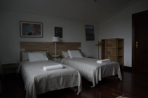 Dos camas individuales en el apartamento LURRA del hotel Bizkar Bare, Vizcaya, con vistas a la montaña y mobiliario moderno