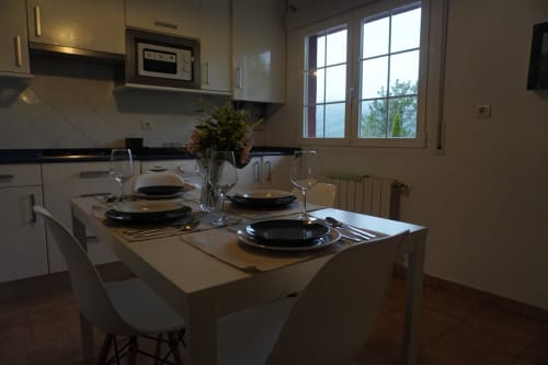 Moderna cocina-comedor en el apartamento Bizkar Bare de Vizcaya con mesa dispuesta y vistas a la montaña