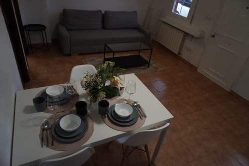 Mesa de comedor elegantemente dispuesta en el apartamento Bizkar Bare en Vizcaya, con sala de estar y sofá visible al fondo