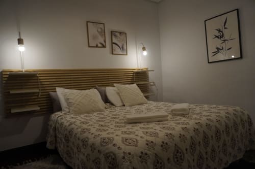 Habitación moderna en Bizkar Bare, Vizcaya, con cabecero rayado, ropa de cama estampada y arte botánico en la pared
