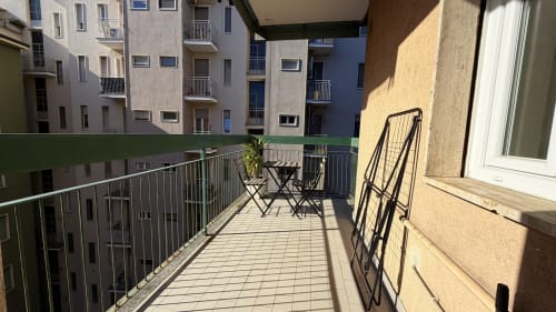 Balcone soleggiato con tavolo da pranzo con vista sui palazzi del quartiere Duomo a Milano