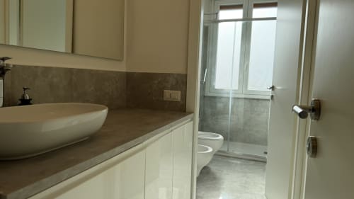 Bagno moderno nell'appartamento Nessa's Home, Opera con lavandino a bacinella, doccia in vetro e finiture chiare