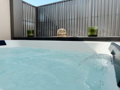 Bain à remous bleu turquoise à l'hôtel ARLOÉ de La Rochelle avec paravent en métal et bougies vertes