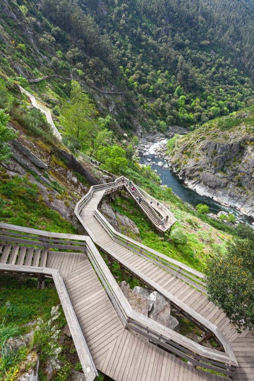 Escadas de passadiço em madeira descendo pela garganta do cânion de Arouca com vistas do rio e floresta na Quinta de Anterronde