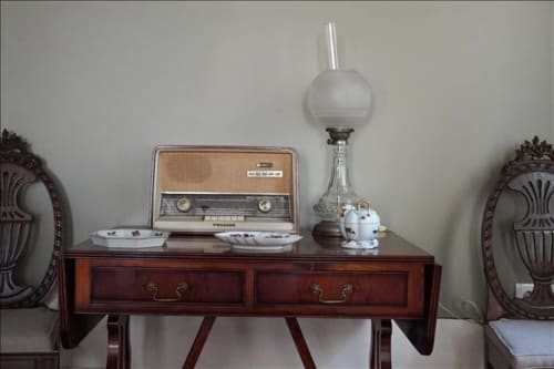 Rádio vintage e luminária a óleo sobre mesa de madeira na Quinta de Anterronde, boutique hotel em Arouca