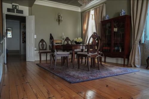 Elegante sala de jantar na Quinta de Anterronde B&B em Arouca com mesa de madeira, cadeiras antigas e mobiliário tradicional