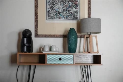 Prateleira de madeira moderna com máquina de café preta, vaso verde e luminária cinza na boutique hotel Quinta de Anterronde, Arouca