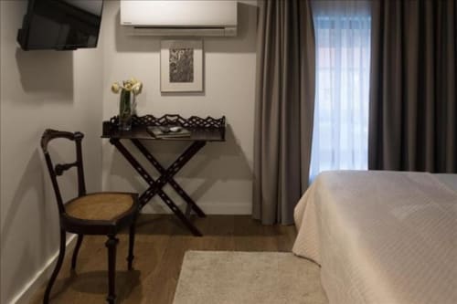 Quarto elegante na Quinta de Anterronde B&B em Arouca com móveis em madeira, quadros emoldurados e luz natural das janelas