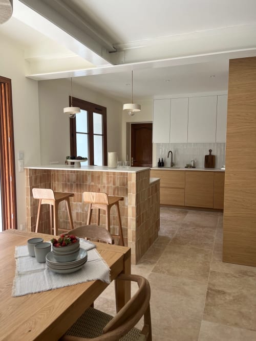 Villa Soleù Mas de Lucienne, cuisine ouverte et salle à manger avec îlot en terre cuite, mobilier bois et vue sur le jardin