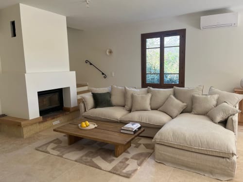 Spacieux séjour de la villa Soleù Mas de Lucienne avec canapé sectionnel beige, cheminée, table basse en bois et jardin