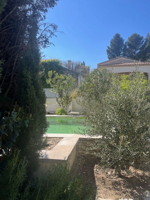 Jardin de la villa Soleù avec piscine turquoise, oliviers et architecture provençale sous un ciel bleu