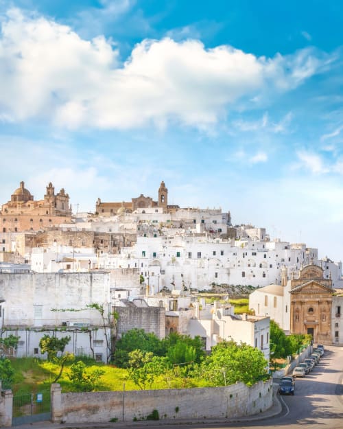Affascinante paese collinare imbiancato a calce con chiesa a cupola e architettura storica, Ostuni Italia