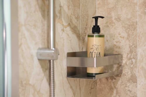 Lussuosi articoli da bagno a Mazzini Suites Palermo con dispenser di sapone all'oliva su parete in marmo