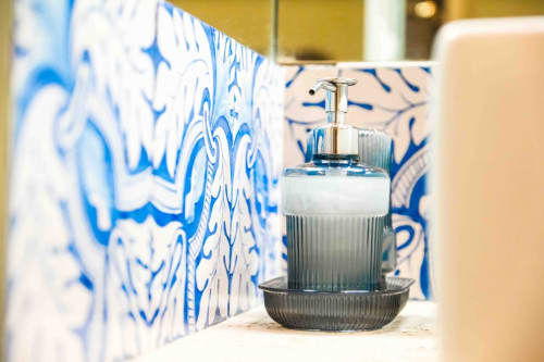 Lussuosi amenities del bagno presso Mazzini Suites Palermo con piastrelle decorative blu e bianche e dispenser di sapone sul lavabo