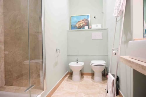 Lussuoso bagno delle Mazzini Suites Palermo con doppi lavabi, bidet, doccia in vetro e arredamento costiero