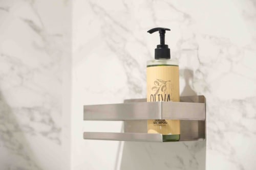 Bathroom amenities shelf at Mazzini Suites Palermo featuring olive oil shampoo bottle with pump dispenser