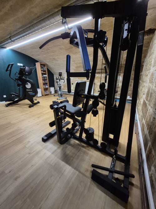 Modern fitness gym at Pavillon Des Millesimes SPA with strength training equipment in Lussac