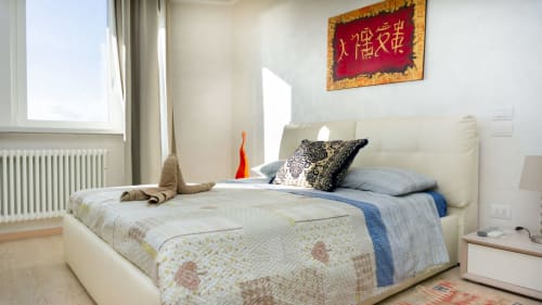 Luxury bedroom at Versilia Panoramic with cream bed, blue bedding, Chinese art, sea views from window, Como Italy
