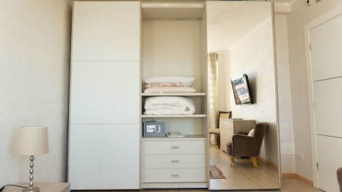 Luxury apartment closet at Versilia Panoramic Hotel Como, Italy with mirrored doors and built-in storage shelving