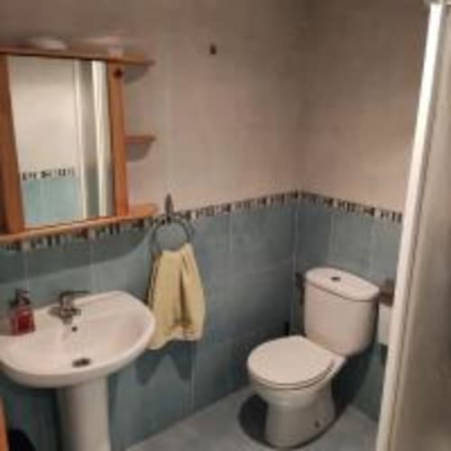 Clean bathroom with pedestal sink, toilet, and blue tile walls at Love Rent4 Malaga apartment in Torremolinos