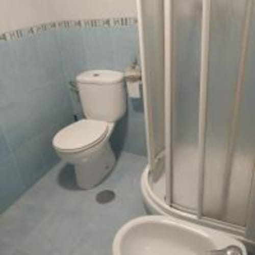 White toilet and shower enclosure in bathroom at Love Rent4 Malaga apartment, Torremolinos