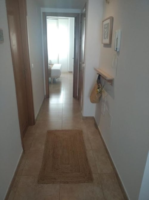Bright hallway with tile flooring in Love Rent4 Malaga apartment, leading to bedroom with natural light