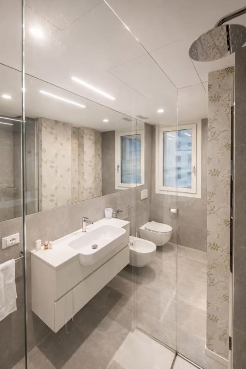 Bagno moderno presso Le Dimore di Giò Verde, appartamento a Ortona: vanità, toilette, bidet, doccia a pioggia e ampio specchio