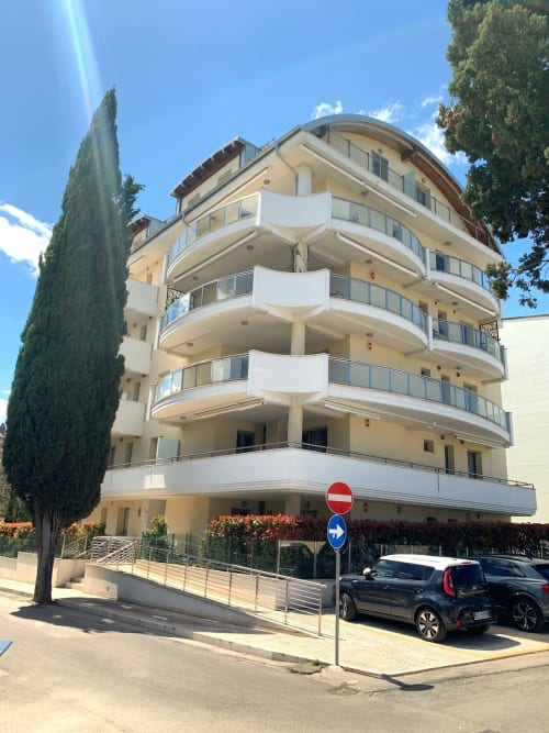 Edificio residenziale moderno Le Dimore di Giò a Ortona, Italia con balconi curvi e cipresso