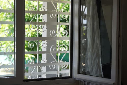 Decorative window with ornamental grilles overlooking green garden at Kaz Kafe bed and breakfast in Mamoudzou, Mayotte