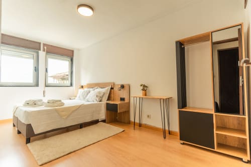Quarto moderno no apartamento DouroParadise em Fontelas com móveis em madeira, vista para o rio e piso em madeira de lei