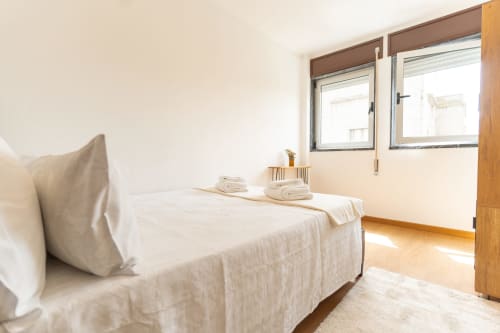 Quarto luminoso no apartamento DouroParadise, Fontelas, com vista para o rio, roupa de cama branca, piso de madeira e janelas com vistas para o