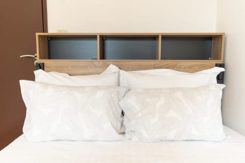Cabeceira moderna em madeira com armazenamento acima de almofadas brancas no apartamento DouroParadise, Portugal