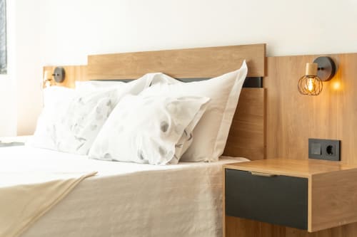 Quarto moderno com cabeceira de madeira, almofadas brancas e luminária no apartamento DouroParadise em Fontelas com vista para o rio