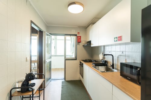 Cozinha moderna no apartamento DouroParadise, Fontelas, com eletrodomésticos em aço inoxidável, bancadas de madeira e vistas para o rio