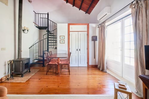 Espaçoso loft com escada de caracol, assoalho em madeira, mesa de jantar e vistas para o jardim em Quinta da Alcaidaria-Mór