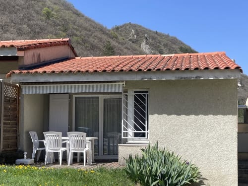 Appartement Pavillon 103 Le Vallon des Sources à Digne-les-Bains avec terrasse, chaises blanches et vue montagne