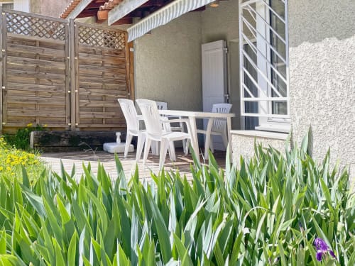 Terrasse privée de l'Appartement 103 au Vallon des Sources, Digne-les-Bains, avec chaises blanches, écran de confidentialité en bois et